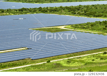 Aerial view of big sustainable electric power plant with many rows of solar photovoltaic panels for producing clean electrical energy. Renewable electricity with zero emission concept 129132436