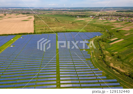 Aerial view of big sustainable electric power plant with many rows of solar photovoltaic panels for producing clean ecological electrical energy. Renewable electricity with zero emission concept. Aerial view of big sustainable electric power plant with many rows of solar photovoltaic panels for producing clean ecological electrical energy. Renewable electricity with zero emission concept. 129132440