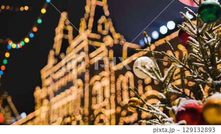 Christmas tree with colorful balls decorating Moscow GUM building at night 129132893