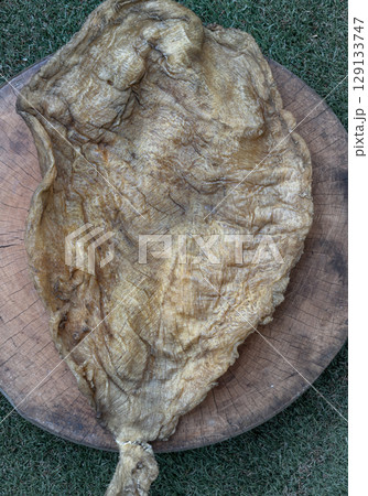 Detail of Fish Maw Soup or Dried Fish Stomach on Old wooden cutting board. Detail of Fish Maw Soup or Dried Fish Stomach on Old wooden cutting board. 129133747