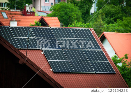 House roof with photovoltaic modules. Historic farm house with modern solar panels on roof and wall High quality photo House roof with photovoltaic modules. Historic farm house with modern solar panels on roof and wall High quality photo 129134228