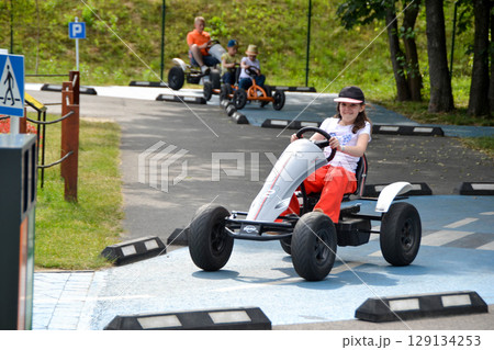 Girl driving quad bike, four wheel cycle car, spring brightly morning, sunny day. High quality photo 129134253