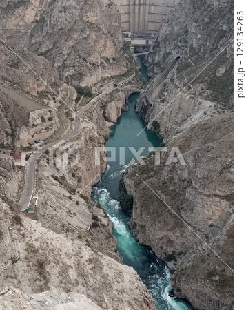 Aerial view of Chirkeyskaya HPP, Sulak Canyon hydroelectric power station, Dubki village, Dagestan, Russia, a powerful stream of turquoise water 129134263