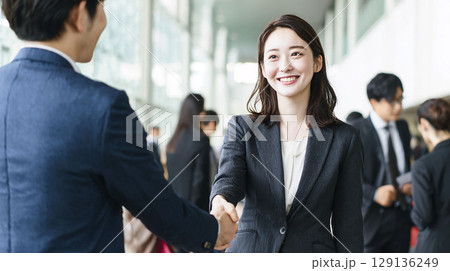 採用が決まり笑顔で握手する若いビジネスウーマン（内定・転職・入社・歓迎） 129136249