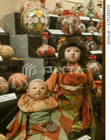 段飾りをバックに立つ2体の市松人形 129136870