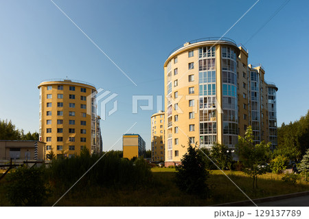 Contemporary Apartment Buildings Gracefully Set Against a Vibrant Blue Sky on a Beautiful Bright Day Contemporary Apartment Buildings Gracefully Set Against a Vibrant Blue Sky on a Beautiful Bright Day 129137789