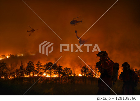 Fire fighting helicopter carry water bucket to extinguish the forest fire. 129138560