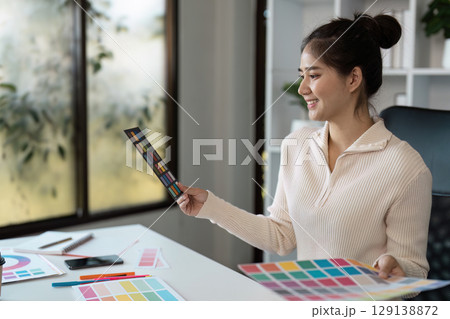 Creative Graphic Designer Working with Color Palettes in Modern Office Environment 129138872