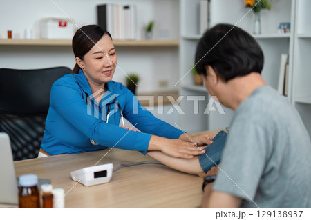 Doctor measuring blood pressure of patient in clinic 129138937