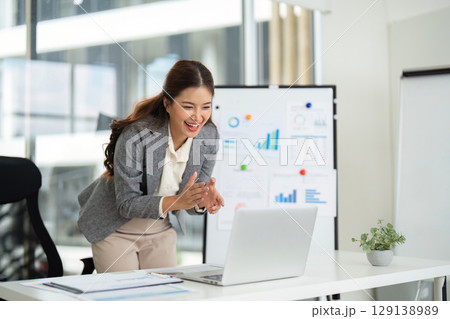 Professional Woman Celebrating Success in Modern Office 129138989