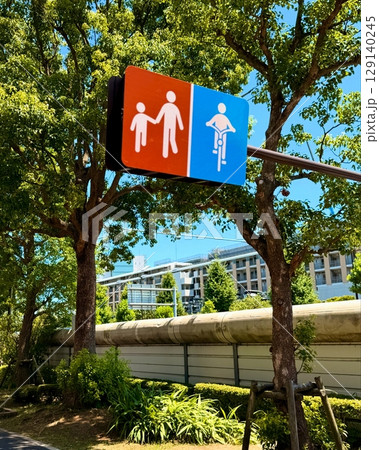 青空の下に立つカラフルなトイレ案内サインと街の風景 129140245