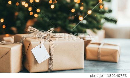 Beautifully wrapped gifts with personalized tags beneath decorated Christmas tree, creating warm and festive atmosphere in New Year winter holiday seasonal celebration 129140778
