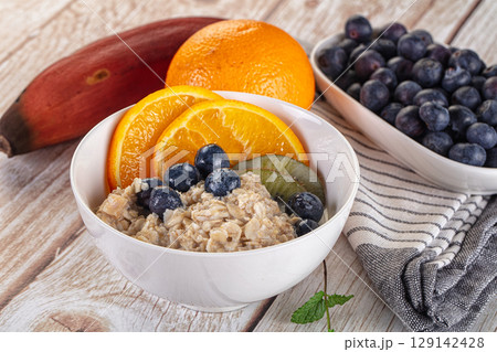 Oats porridge with blueberry, kiwi and orange Oats porridge with blueberry, kiwi and orange 129142428