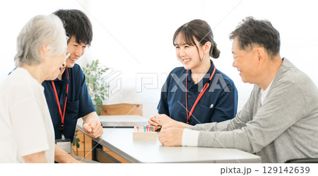 リハビリでシリンダーペグを使い手指機能訓練をするシニアと作業療法士の男女 129142639
