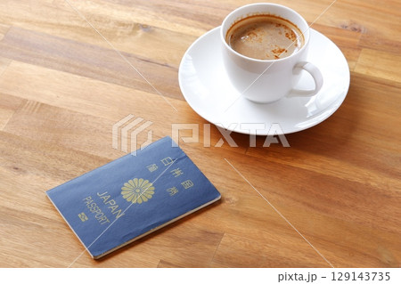 パスポート(一般旅券5年用紺色)を用意して、コーヒーを飲みながら、海外旅行を計画しているイメージ パスポート(一般旅券5年用紺色)を用意して、コーヒーを飲みながら、海外旅行を計画しているイメージ 129143735
