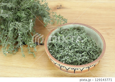 Dried greek oregano, lat. Origanum hirtum on wooden table. 129143771