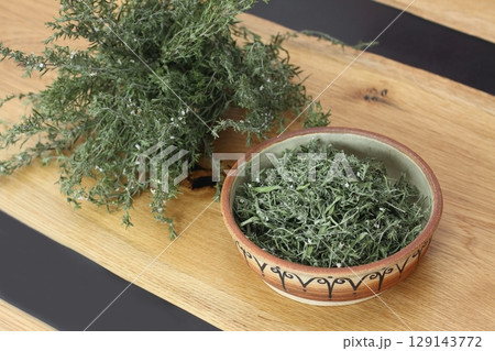 Dried greek oregano, lat. Origanum hirtum on wooden table. 129143772