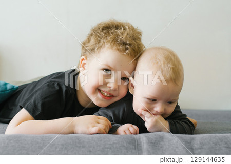 Happy Brothers Lying On Gray Sofa Happy Brothers Lying On Gray Sofa 129144635