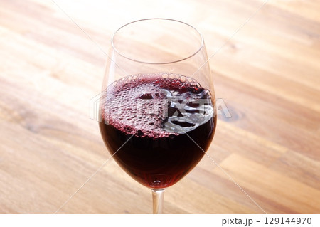 ワイングラスに注がれた赤ワイン 129144970