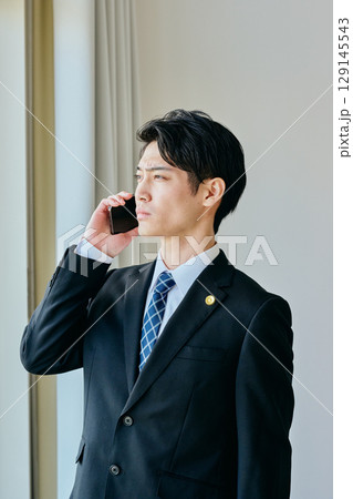 電話をする20代の若い弁護士 電話をする20代の若い弁護士 129145543