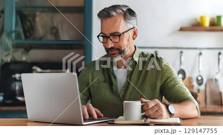 positive delighted man working on his laptop 129147755