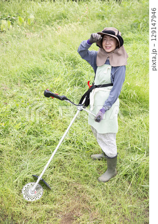 草刈り機で除草する、働く日本の女性、農家 草刈り機で除草する、働く日本の女性、農家 129147946