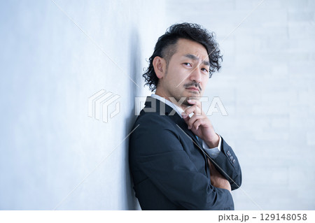 顎に手を当てて考えるスーツの髭のビジネスマン上半身 129148058