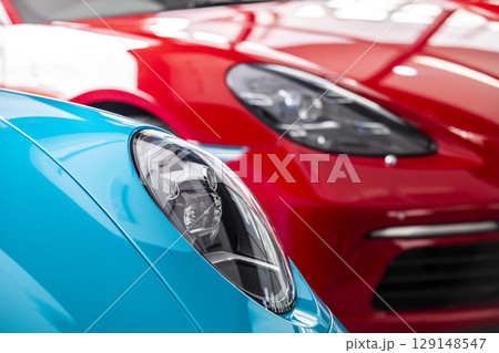 Car headlight of blue and red automobile. Car headlight of blue and red automobile. 129148547