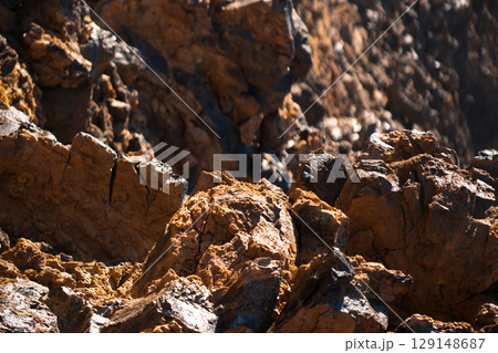 Lava formations, stones, black basalt in the rocks closeup on a volcano terrain. 129148687