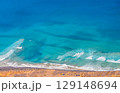 Blue ocean with waves and a sandy beach, top view. 129148694