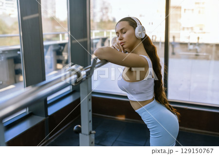 Sexy girl wearing sportswear is posing next smith machine in the fitness center. 129150767