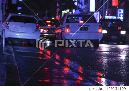 濡れた道路に映るネオンと自動車 129151199