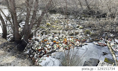 Dirty river is polluted with many plastic bottles. A lot of trash is dumped in open and freely available places at nature. Global environmental pollution problem. Concept of ecological disaster Dirty river is polluted with many plastic bottles. A lot of trash is dumped in open and freely available places at nature. Global environmental pollution problem. Concept of ecological disaster 129151734