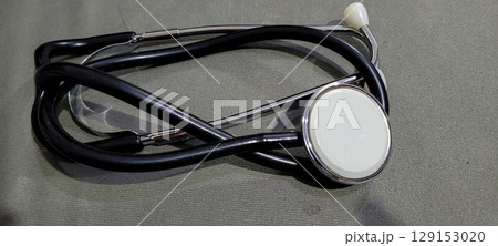 A stethoscope placed on a textured fabric surface commonly used in medical settings A stethoscope placed on a textured fabric surface commonly used in medical settings 129153020
