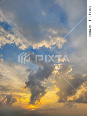 A Dramatic Sunset with Colorful Clouds Stretching Across the Sky, Capturing Beauty and Light 129153051