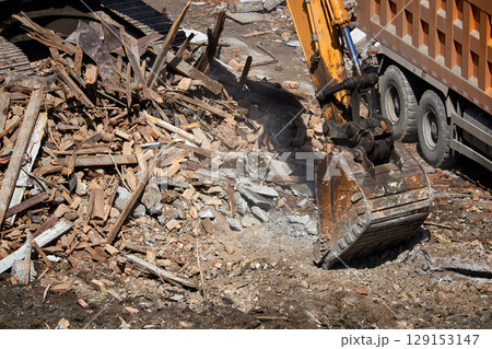 excavator bucket on dismantling site, side view. excavator bucket on dismantling site, side view. 129153147