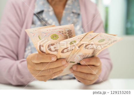 Retired elderly woman counting coins money and worry about monthly expenses and treatment fee payment. Retired elderly woman counting coins money and worry about monthly expenses and treatment fee payment. 129153203