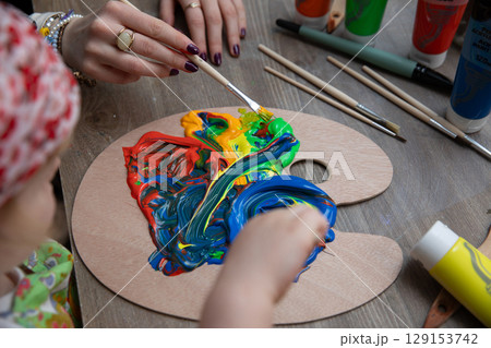 Engaging in a Colorful Painting Activity with a Child and Their Parent for creative fun Engaging in a Colorful Painting Activity with a Child and Their Parent for creative fun 129153742