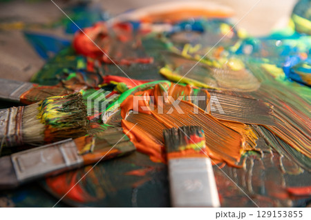 A gorgeous and vibrant abstract palette featuring paint brushes in a captivating closeup view 129153855