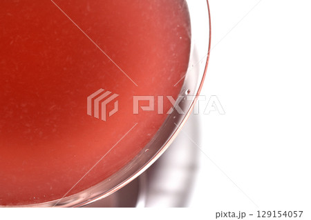 Close up abstract of a red cosmopolitan cocktail in a martini glass on white background 129154057