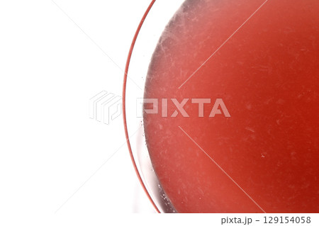Close up abstract of a red cosmopolitan cocktail in a martini glass on white background Close up abstract of a red cosmopolitan cocktail in a martini glass on white background 129154058