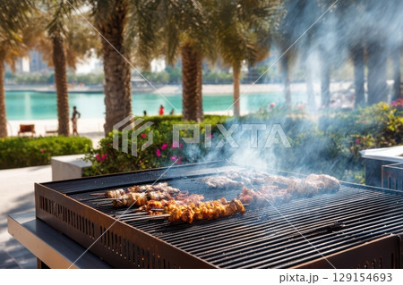 Enjoying a delightful Summer Barbecue experience right by the beautiful sandy Beach under the sun Enjoying a delightful Summer Barbecue experience right by the beautiful sandy Beach under the sun 129154693