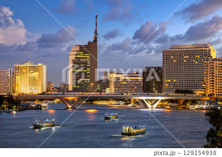 Aerial view of Taksin Bridge with Chao Phraya River, Bangkok Downtown Thailand at twilight time. Financial district and business centers in smart urban city. Aerial view of Taksin Bridge with Chao Phraya River, Bangkok Downtown Thailand at twilight time. Financial district and business centers in smart urban city. 129154938