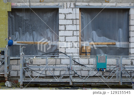 A Construction Site Featuring Unfinished Windows and Scaffolding Elements Awaiting Completion 129155545