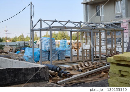 A busy construction site with a strong metal framework and various building materials A busy construction site with a strong metal framework and various building materials 129155550