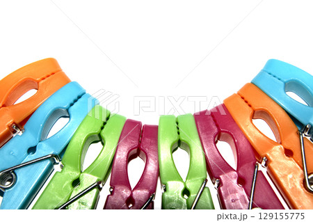 Colourful vibrant clothes pegs on a white background close up for laundry day 129155775