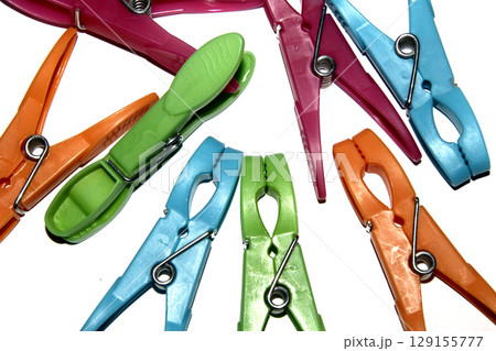 Colourful vibrant clothes pegs on a white background close up for laundry day 129155777