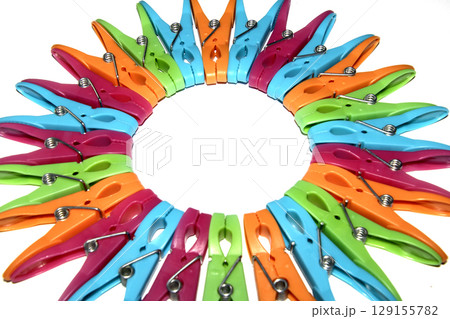 Colourful vibrant clothes pegs on a white background close up for laundry day 129155782