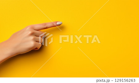Woman's Hand Pointing on Yellow Background. Web Banner with Clean Copy Space 129156263