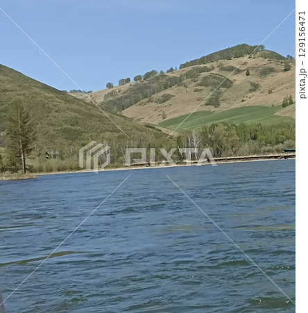 Picturesque Landscape Featuring a Tranquil River Flowing Through Rolling Hills and Lush Greenery Picturesque Landscape Featuring a Tranquil River Flowing Through Rolling Hills and Lush Greenery 129156471